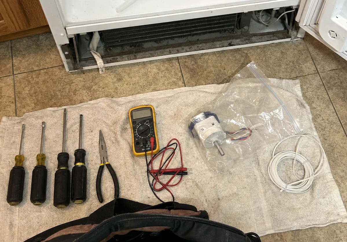 Centre crop of the flat-lay, the multimeter and a bagged replacement motor sharp on the folded towel.